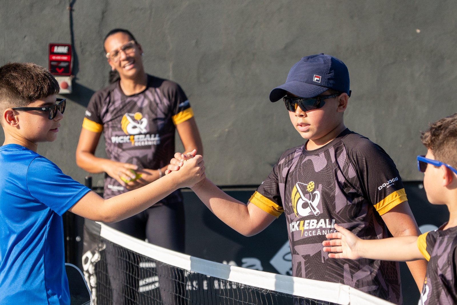 Crianças se cumprimentando na quadra de pickleball
